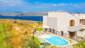 A modern villa with a swimming pool, a stone pathway, and a view of the sea and distant mountains. - Villa Stratos Large Private Pool Sea Views A C Wifi Eco-friendly - 2117 (Chania)