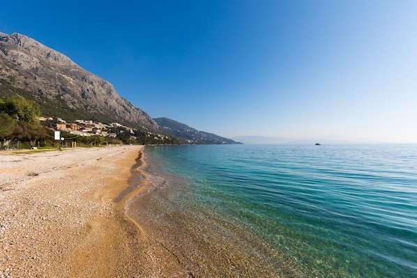 Enjoy a serene coastal escape with a pebble beach and calm waters.