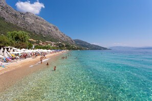 A beach with clear water, umbrellas, and people. - Villa Amalia Large Private Pool Walk to Beach Sea Views A C Wifi - 2120 (Corfu)