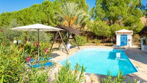 Une piscine avec des chaises longues et une pergola en bois.