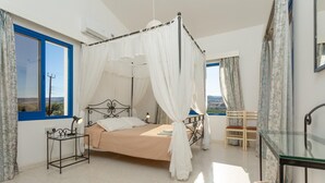 Une chambre à coucher avec un lit à baldaquin, une table de chevet avec une lampe, une chaise et une table en verre.