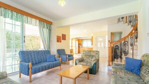 A spacious living room with patterned sofas, a wooden coffee table, and a staircase with ornate railings. - Villa Iliada Large Private Pool Walk to Beach A C Wifi Car Not Required - 2143 (Polis)