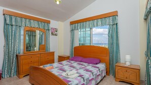 A bedroom with a wooden bed, a nightstand, a dresser, a mirror, and a window with curtains. - Villa Iliada Large Private Pool Walk to Beach A C Wifi Car Not Required - 2143 (Polis)