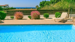 A swimming pool with clear blue water, surrounded by a tiled deck and various shrubs. - Villa Clementina Large Private Pool Walk to Beach Sea Views A C Wifi Eco-friendly - 2183 (Ayia Marina Chrysochous)