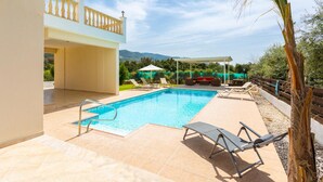 A swimming pool with lounge chairs, a covered seating area, and a view of a mountain range. - Villa Rose Large Private Pool Walk to Beach Sea Views A C Wifi - 2184 (Ayia Marina Chrysochous)