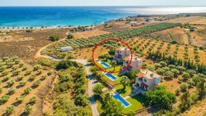 An aerial view of a coastal property with a swimming pool, multiple buildings, and a view of the sea. - Theo Beach Villa Large Private Pool Walk to Beach Sea Views A C Wifi Car Not Required - 1843 (Sfakia)