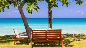 A wooden bench and chair under a tree by a clear blue sea. - Villa Constantinos Large Private Pool Walk to Beach Sea Views A C Wifi Car Not Required - 2220 (Ayia Marina Chrysochous)