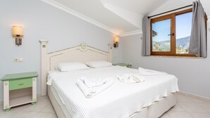 A neatly made bed with white linens and towels, a green nightstand with a drawer, and a window with a view of the outdoors. - Villa Melek Paradise Private Pool A C Wifi Car Not Required Eco-friendly - 2235 (Ortaca)