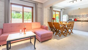 A modern living room with a sofa, coffee table, and dining area with chairs. - Villa Melek Paradise Private Pool A C Wifi Car Not Required Eco-friendly - 2235 (Ortaca)