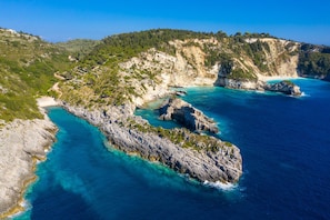 A coastal landscape with rocky terrain and clear blue waters.