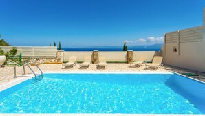 A rooftop pool with clear blue water, surrounded by lounge chairs and a stone wall. - Villa Anastasia Large Private Pool Walk to Beach Sea Views A C Wifi Car Not Required - 2248 (Paxos)