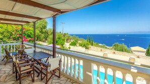 A covered outdoor seating area with a view of the sea and greenery. - Villa Anastasia Large Private Pool Walk to Beach Sea Views A C Wifi Car Not Required - 2248 (Paxos)