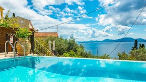 Una piscina con vistas a una masa de agua y montañas al fondo.
