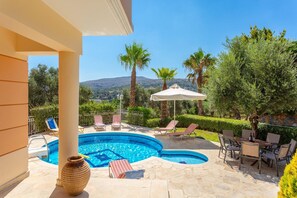 Un espace piscine privé comprenant des chaises longues, une table et un vase décoratif.