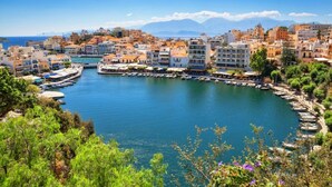 A coastal town with a marina, buildings with balconies, and a clear view of the sea and mountains in the background. - Villa Maro Large Private Pool A C Wifi - 2424 (Apokoronas)