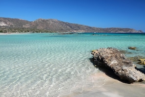 A clear turquoise sea with a rocky outcrop in the foreground and mountains in the background. - Villa Arda Large Private Pool Sea Views A C Wifi - 2425 (Apokoronas)