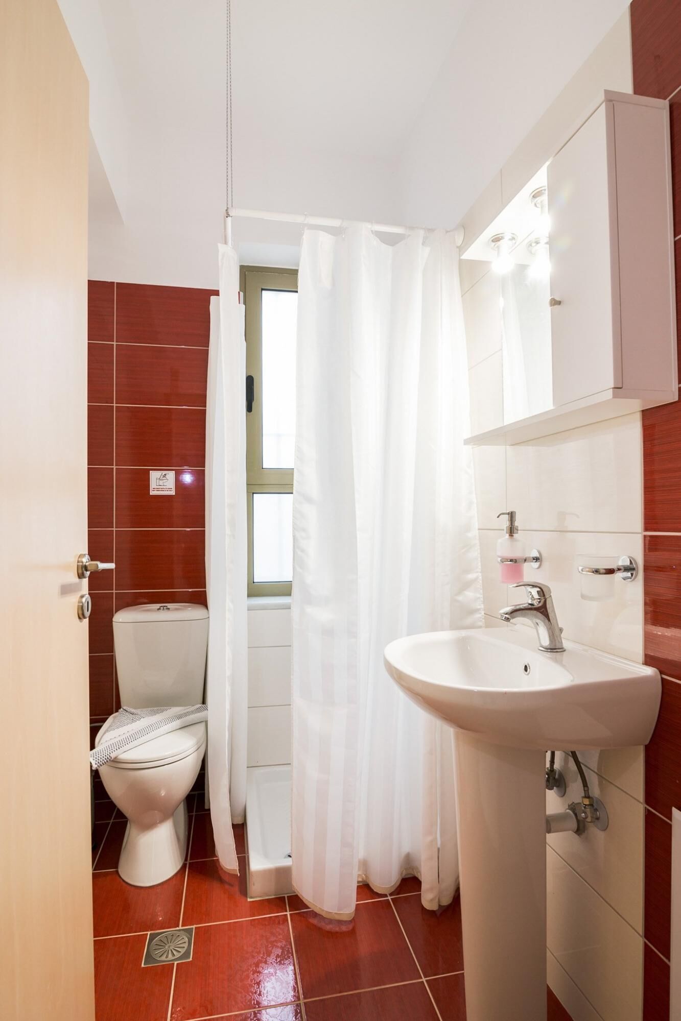 A bathroom with a toilet, a sink, and a shower curtain.