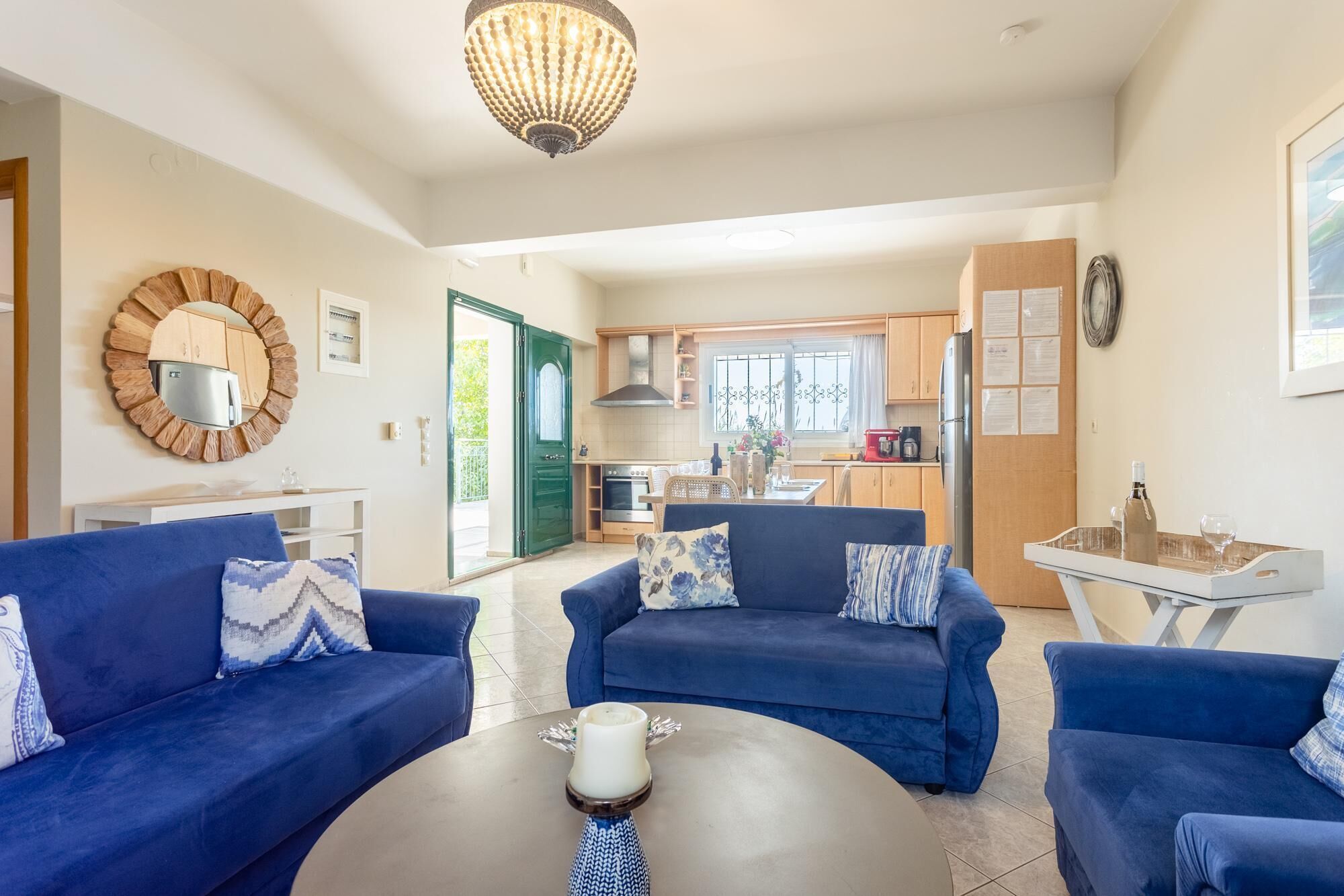 Ein modernes Wohnzimmer mit zwei blauen Sofas, einem runden Couchtisch und einer Deckenleuchte.