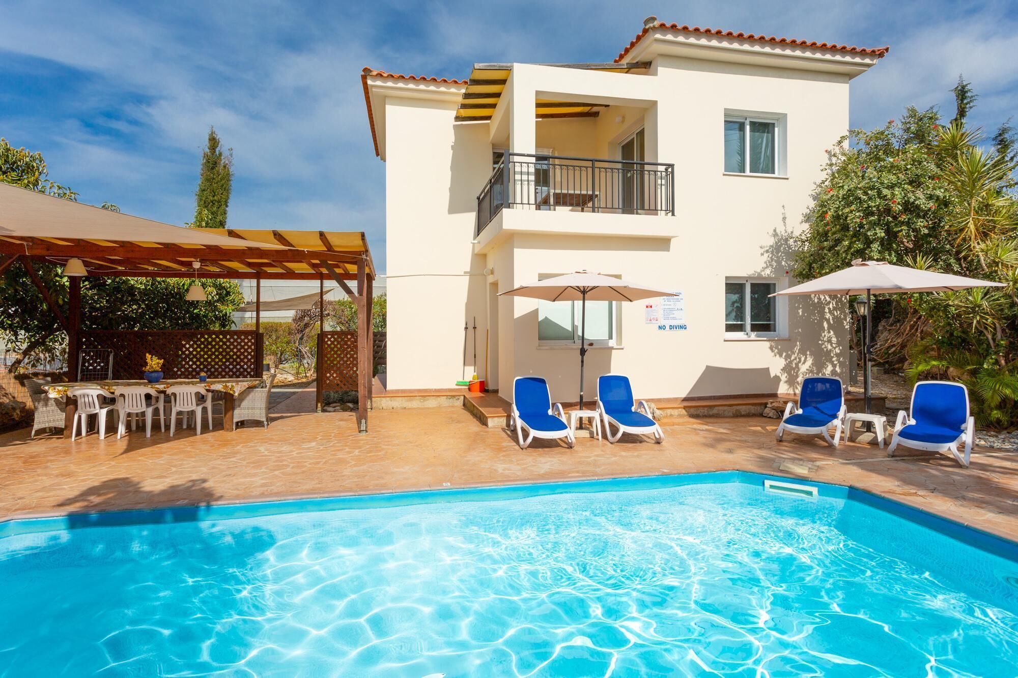 Un bâtiment à deux étages doté d’une piscine, d’un espace extérieur aménagé et d’un patio couvert.