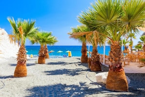A beach with palm trees, a sandy path, and a wooden deck with chairs. - Villa Charoula Tessera Large Private Pool A C Wifi Eco-friendly - 2743 (Polis)