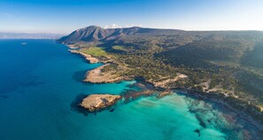 An aerial view of a coastal landscape with a prominent mountain, clear turquoise waters, and a narrow strip of land with vegetation. - Villa Argaka Sunset Large Private Pool Walk to Beach Sea Views A C Wifi Eco-friendly - 2760 (Argaka)