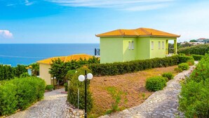 A two-story house with a tiled roof, a stone pathway, and a view of the sea. - Skala Villa Green Large Private Pool Walk to Beach Sea Views A C Wifi - 2825 (Kefalonia)