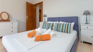 A neatly made bed with white and orange towels, a blue headboard, and striped pillows. - Villa Glafki Large Private Pool Sea Views A C Wifi - 2829 (Skopelos)
