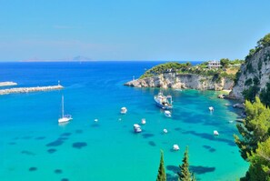 A coastal area with boats, a lighthouse, and a building on a cliff. - Neptune Private Pool Walk to Beach A C Wifi - 2831 (Alonissos)