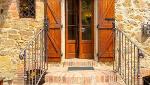 A stone building with a wooden door and a metal staircase leading to the entrance. - Villa Bramasole Large Private Pool Wifi - 2863 (Sinalunga)