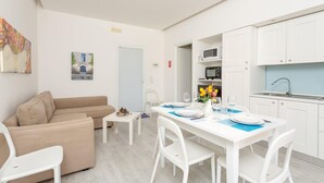 A modern apartment with a dining area, a kitchen, and a living room.