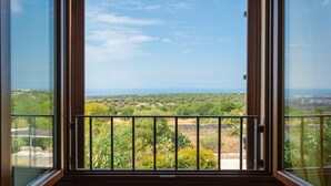 A balcony with a metal railing, a wooden door, and a view of a green landscape with trees and a clear sky. - Villa Palazzola Large Private Pool Sea Views A C Wifi - 2886 (Scicli)