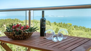 A wooden table with a bottle of wine, two wine glasses, and a woven basket of flowers. - Villa Stephania Private Pool Walk to Beach Sea Views A C Wifi - 2890 (Paxos)