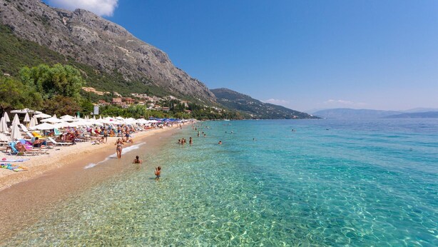 A beach with clear turquoise water, sun loungers, and umbrellas. - Villa Durrell Large Private Pool Walk to Beach A C Wifi - 2927 (Corfu)