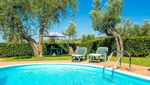 A swimming pool with a clear blue water, surrounded by green chairs and a table with an umbrella. - Villa Le Balze Large Private Pool Wifi - 3016 (Vinci)