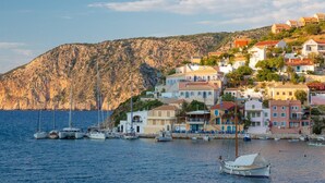 A coastal town with buildings on a hillside, a marina with boats, and a rocky backdrop. - Villa Lassi Illios Large Private Pool Walk to Beach Sea Views A C Wifi - 3055 (Kefalonia)