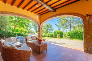 A covered outdoor seating area with wicker furniture and a view of the garden and pool. - Villa Casa al Sole Large Private Pool Wifi - 3078 (Radda in Chianti)