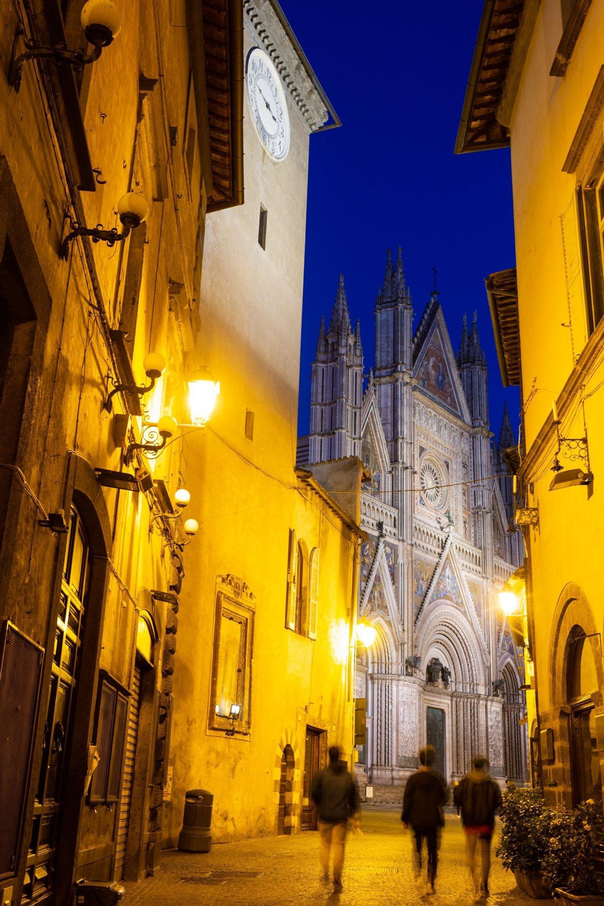 Une rue étroite, avec une grande cathédrale en arrière-plan.