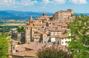 Une ville historique dotée d’une architecture médiévale, notamment une tour imposante et des remparts fortifiés.