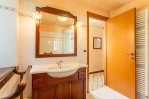 A bathroom with a wooden vanity, a large mirror, and a white sink. - Villa Casale Le Selve Large Private Pool Wifi - 3099 (Castiglione di Garfagnana)