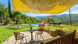 An outdoor patio with stone flooring, a yellow canopy, and a view of a swimming pool and mountains. - Villa Bellavista Large Private Pool Wifi - 3122 (Ortignano Raggiolo)