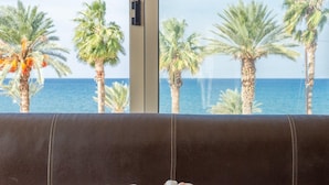 A bed with a view of palm trees and the sea through large windows. - Villa Seashore One Large Private Pool Walk to Beach Sea Views A C Wifi - 3150 (Argaka)