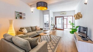 Una sala moderna con un sofá, una mesita de centro y un mueble para la televisión.