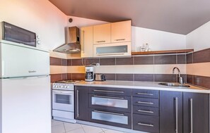 Eine moderne Küche mit eingebautem Backofen, einer Kaffeemaschine und einem Spülbecken.
