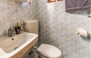Ein Badezimmer mit Waschbecken, Toilette und Duschbereich.