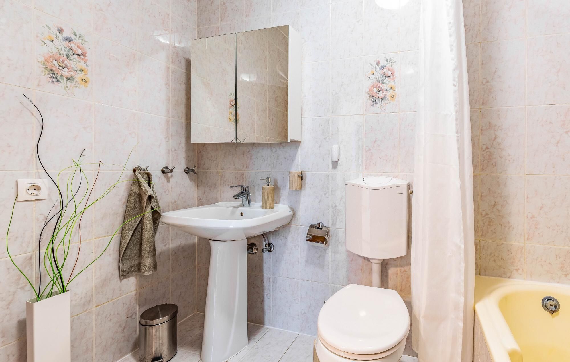 Un baño con lavamanos pedestal, inodoro y bañera.