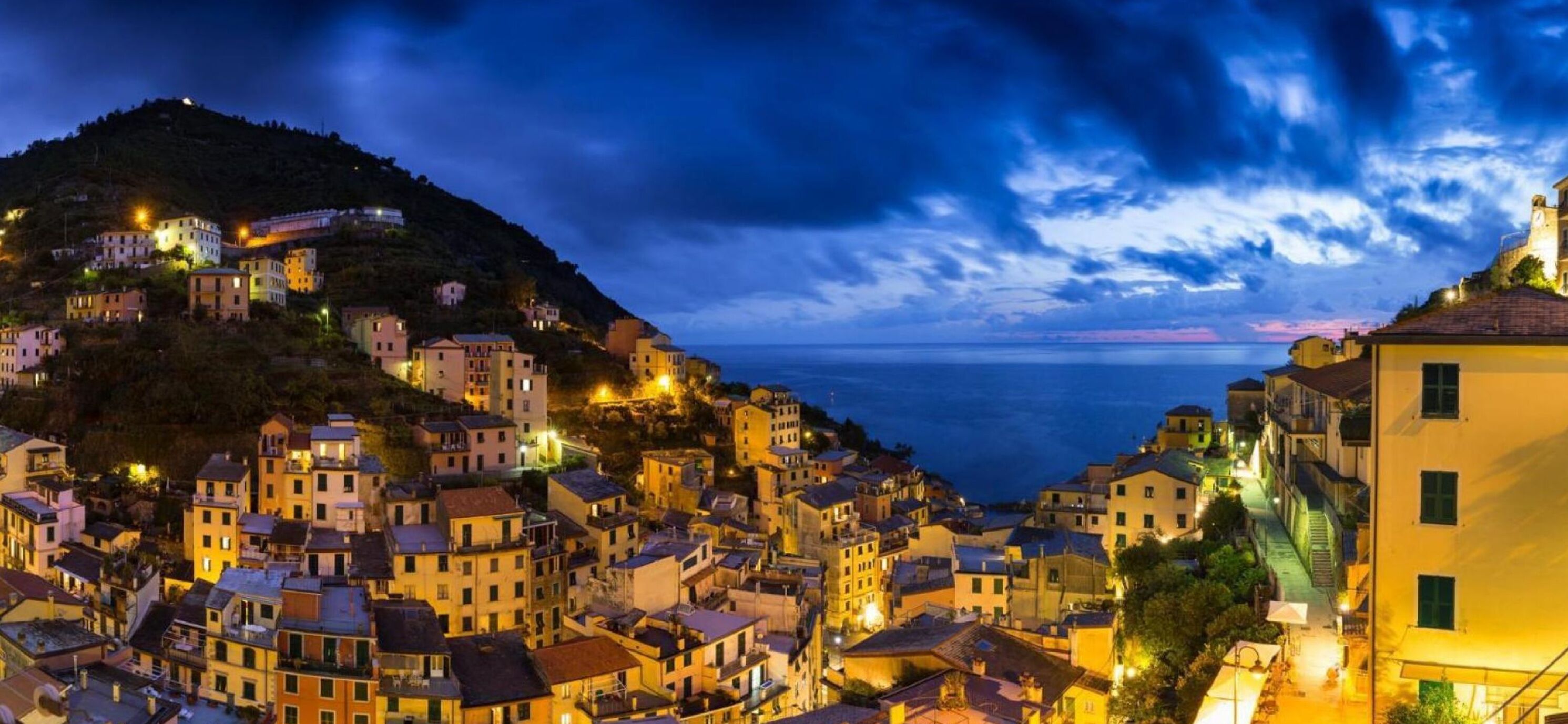 A coastal town with buildings along the hillside and a view of the sea.