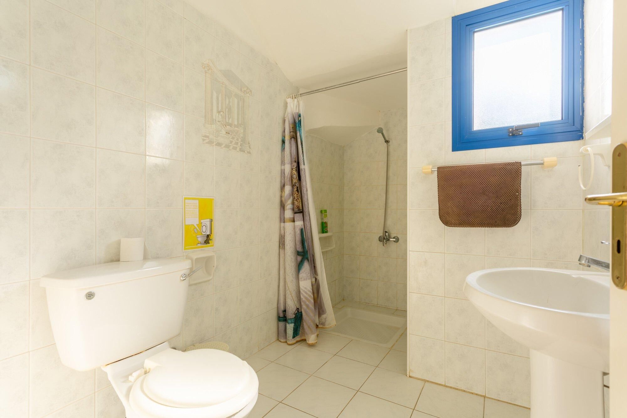 Un baño con inodoro, ducha y lavamanos.