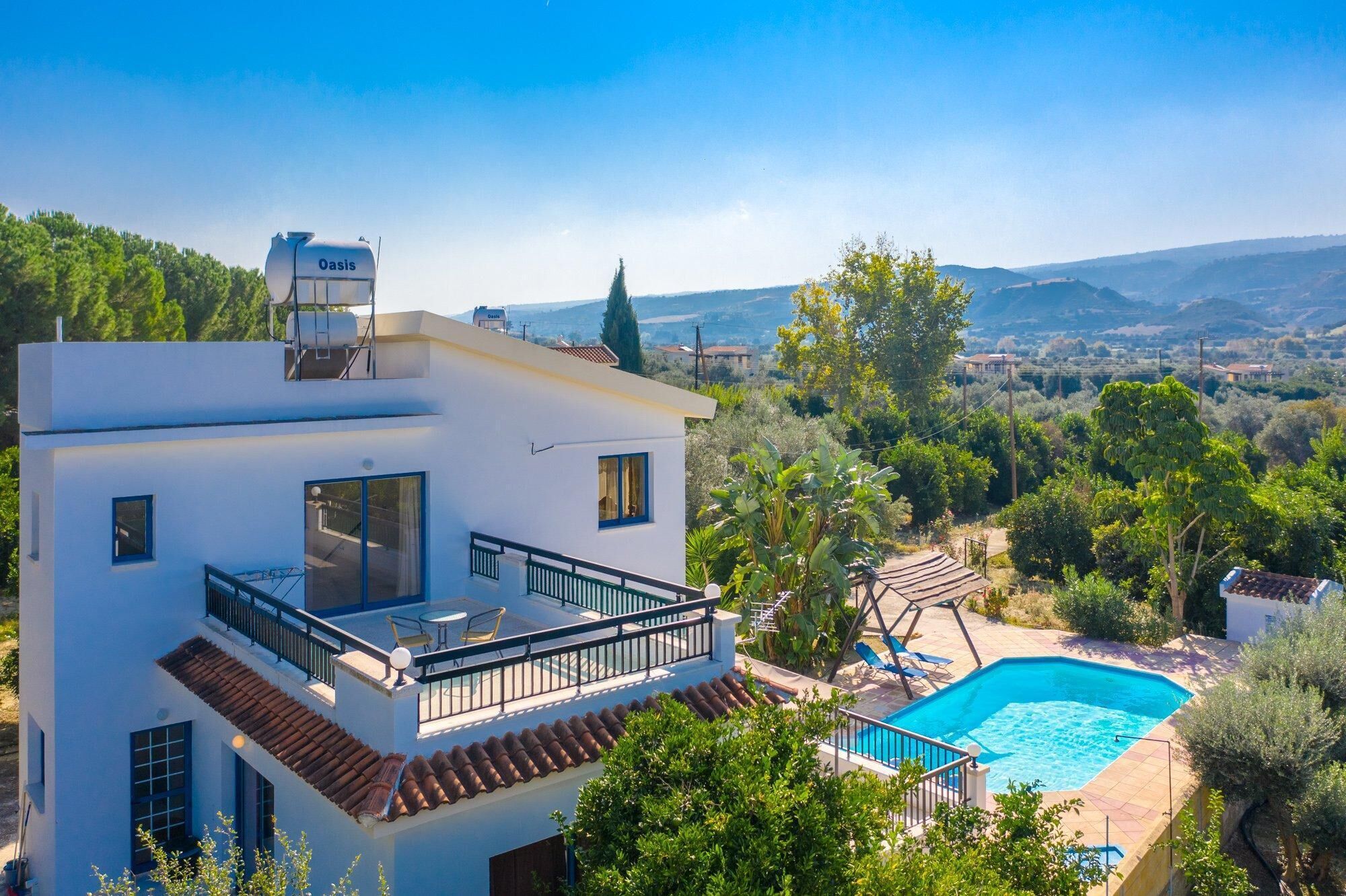 Ein modernes, zweistöckiges Haus mit Dachterrasse, Swimmingpool und einer schönen Aussicht auf die Landschaft.