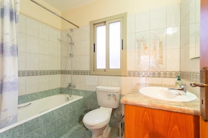 A bathroom with a bathtub, toilet, and sink.
