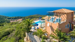 En villa i medelhavsstil med pool, utomhusmöbler och utsikt över havet.